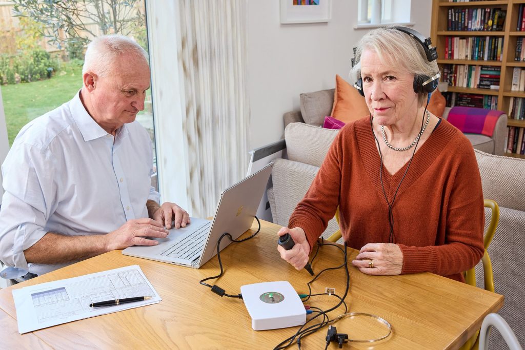 audiologists at the sense of hearing is performing a hearing test on the patient.