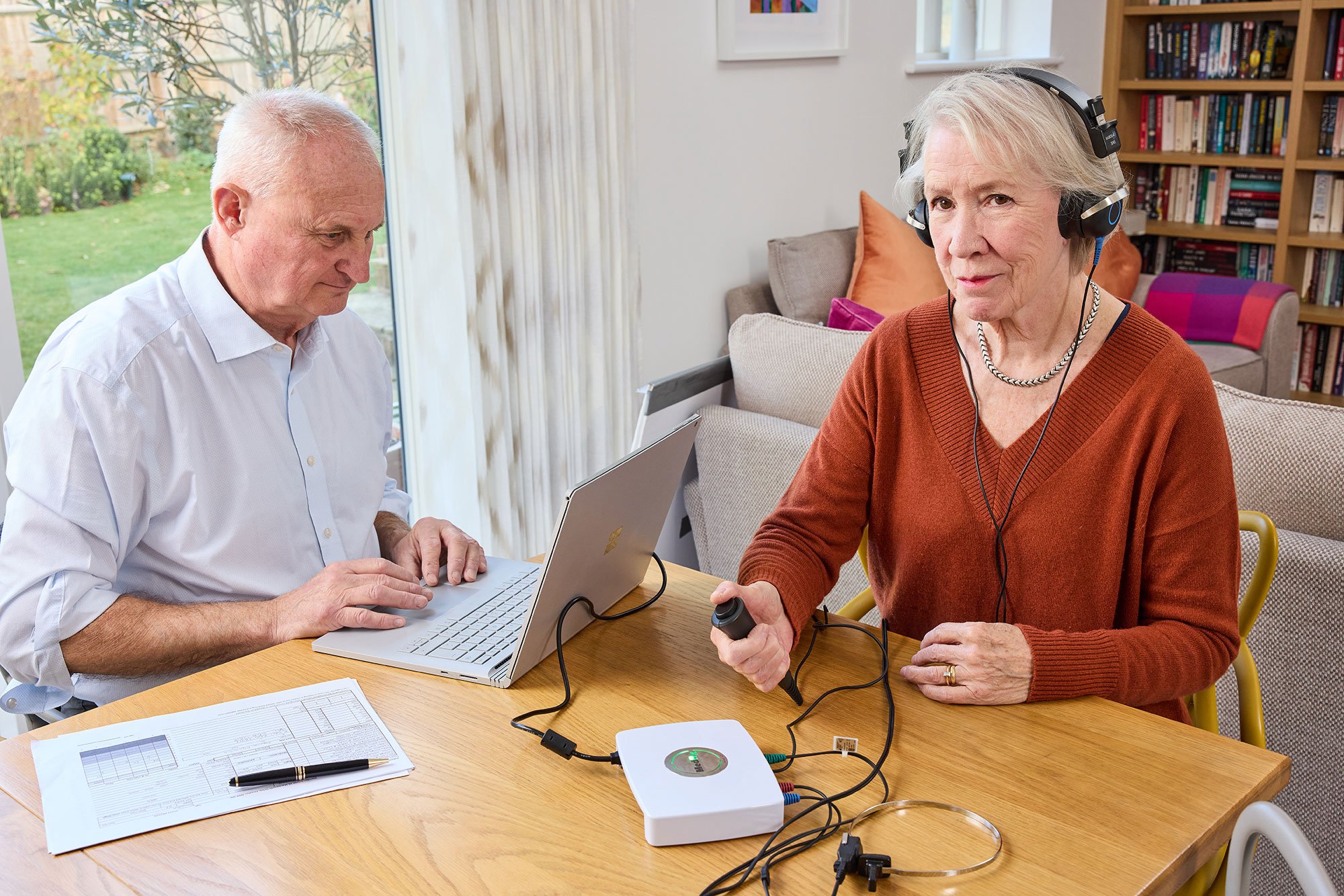 audiologists at the sense of hearing is performing a hearing test on the patient.